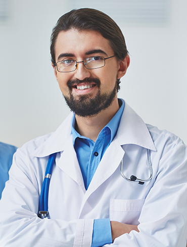 Doctor in a white coat smiling with a stethoscope.
